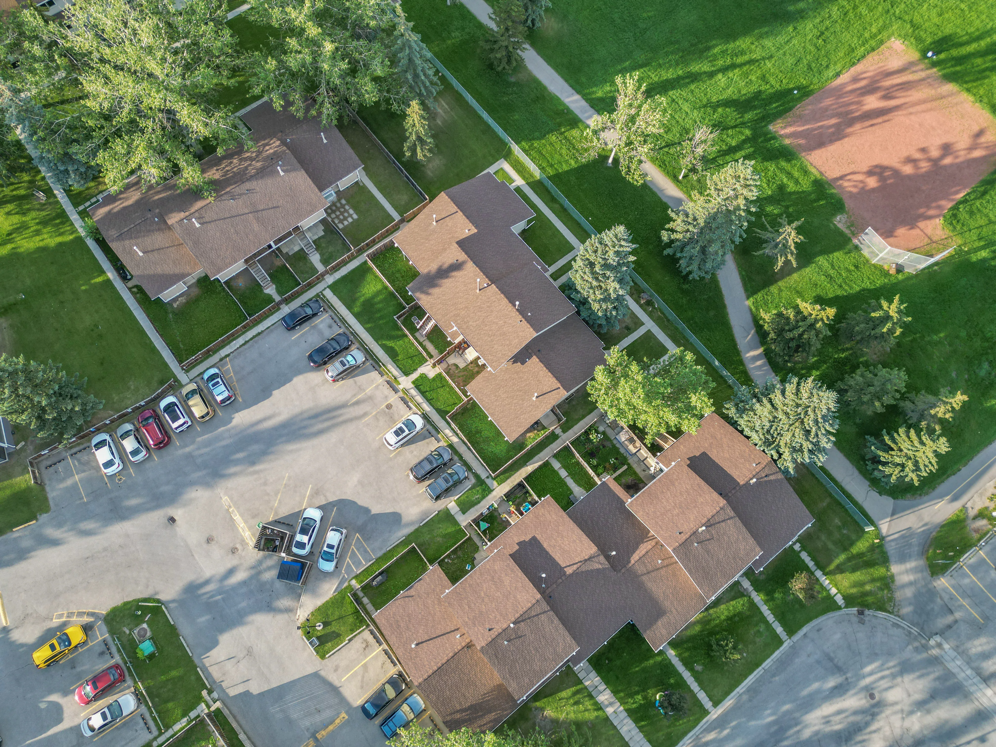 Aerial of townhouse rooftops, parking and trees
