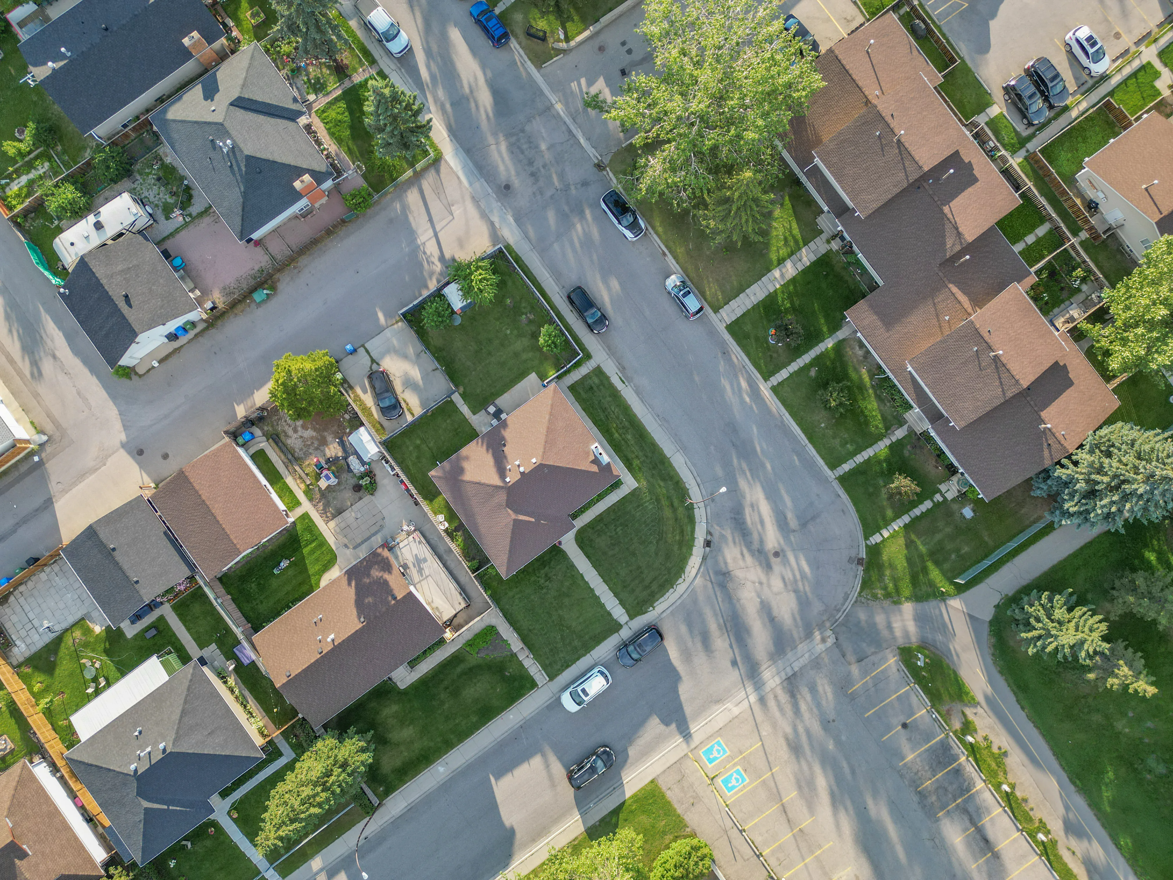Aerial of homes on a curving street with lawns