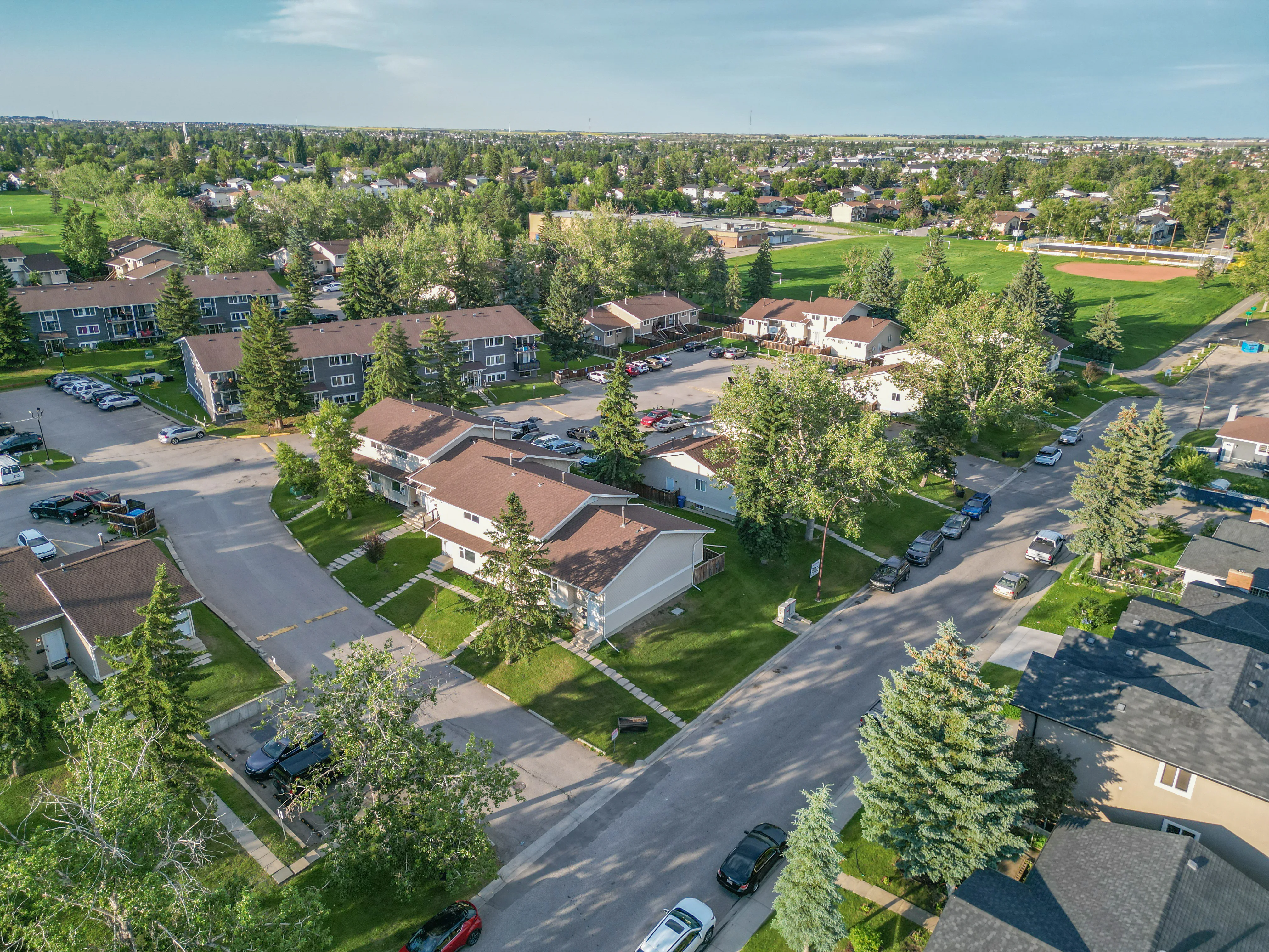 Aerial of detached homes with green yards and mature trees