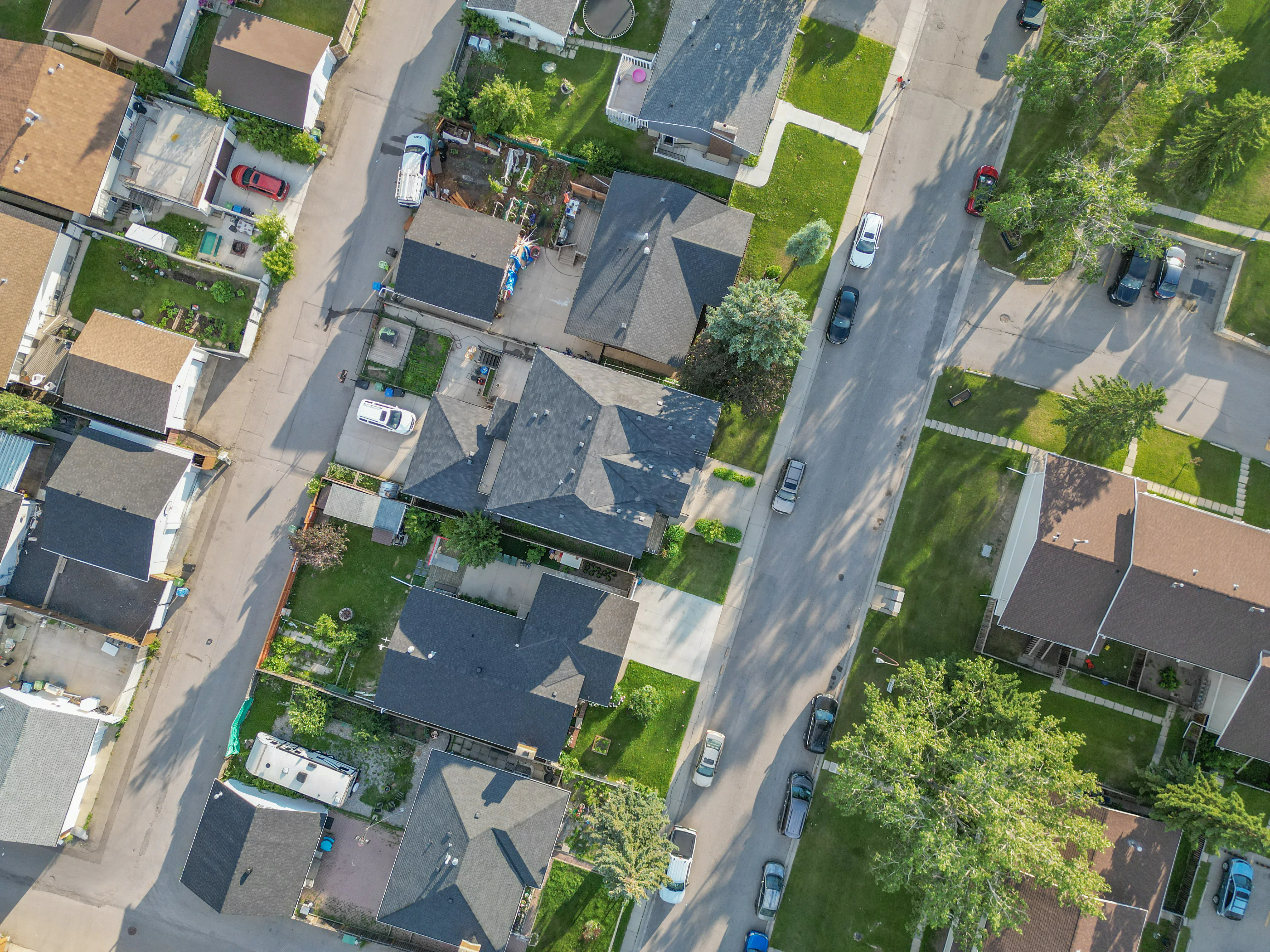 Aerial view looking down on detached homes and backyards
