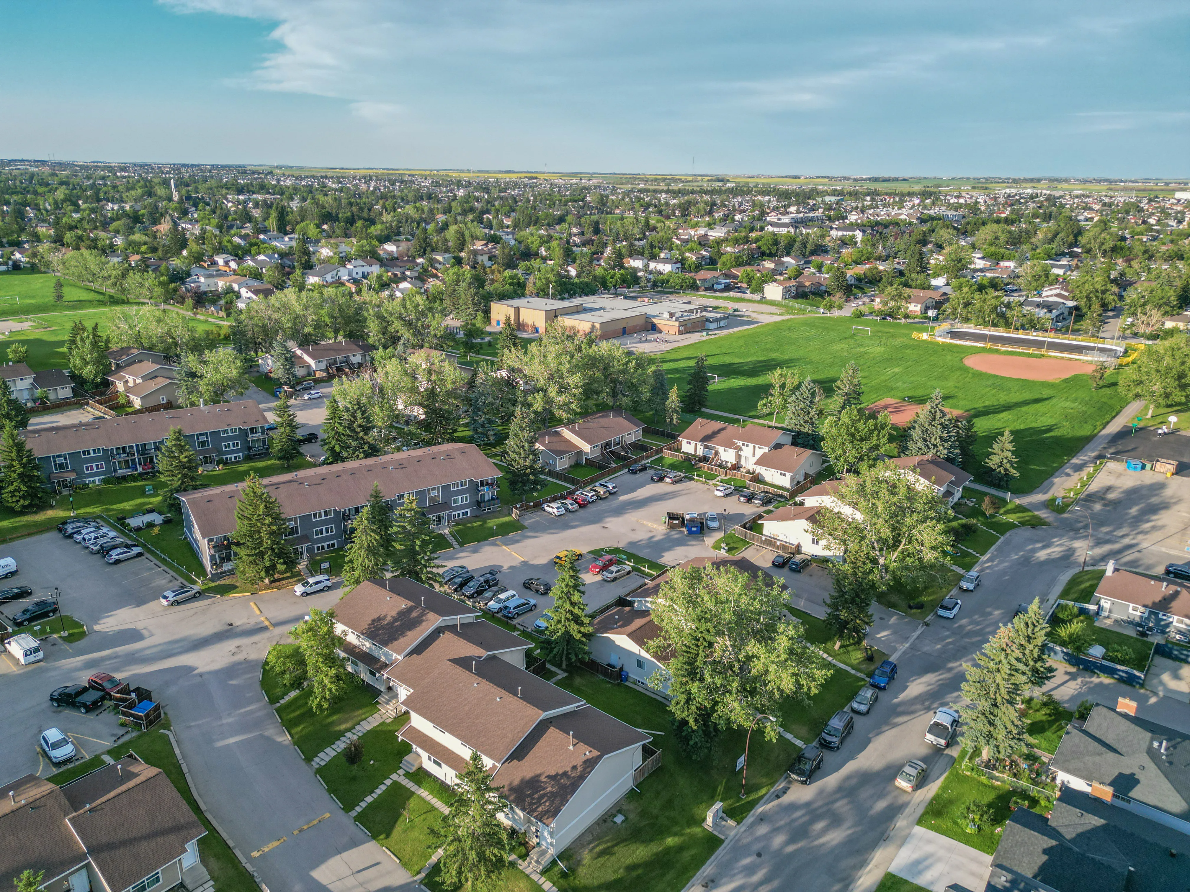 Aerial of homes and green space with mature trees