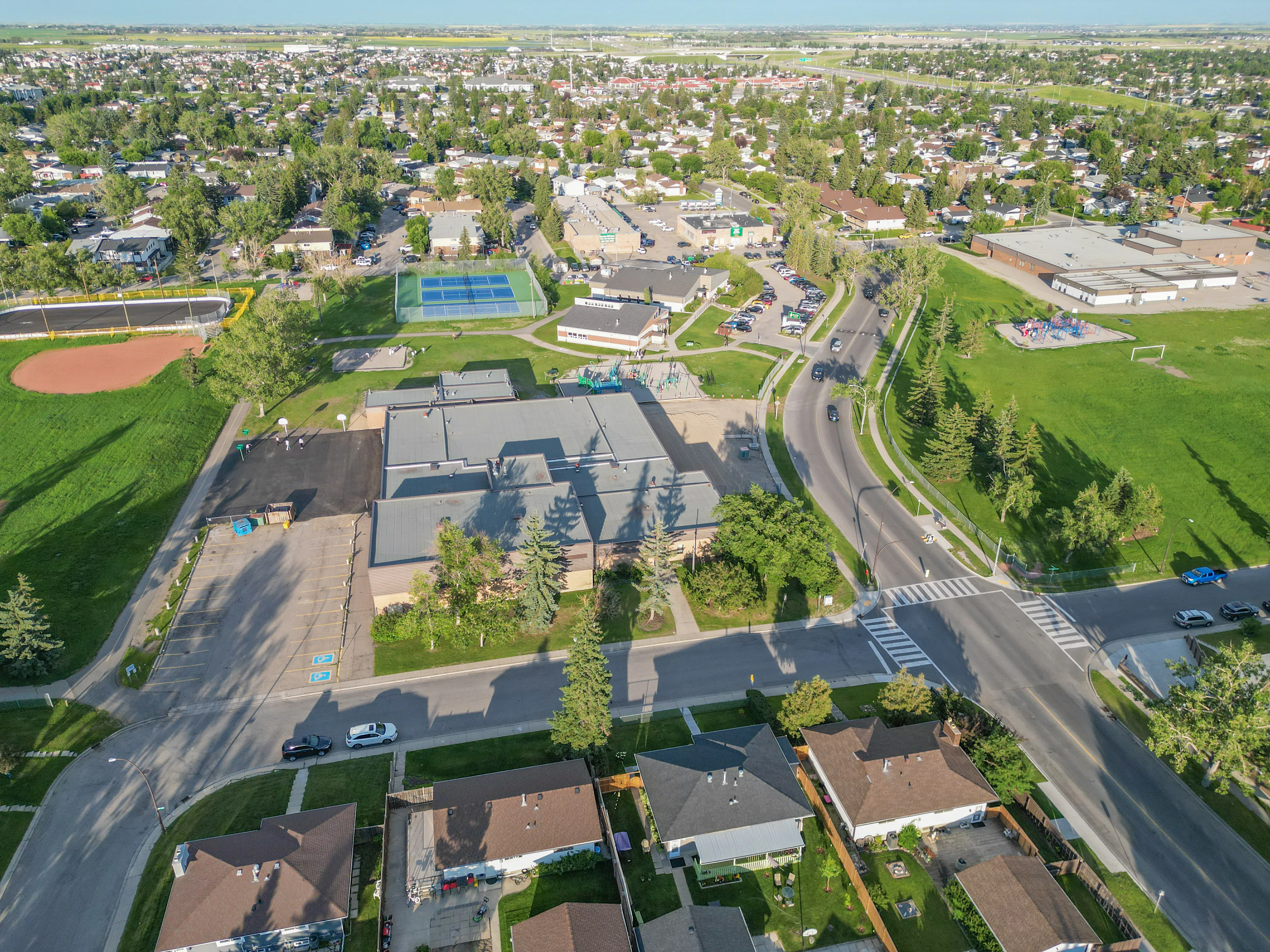 Aerial of a school building with sports fields and homes