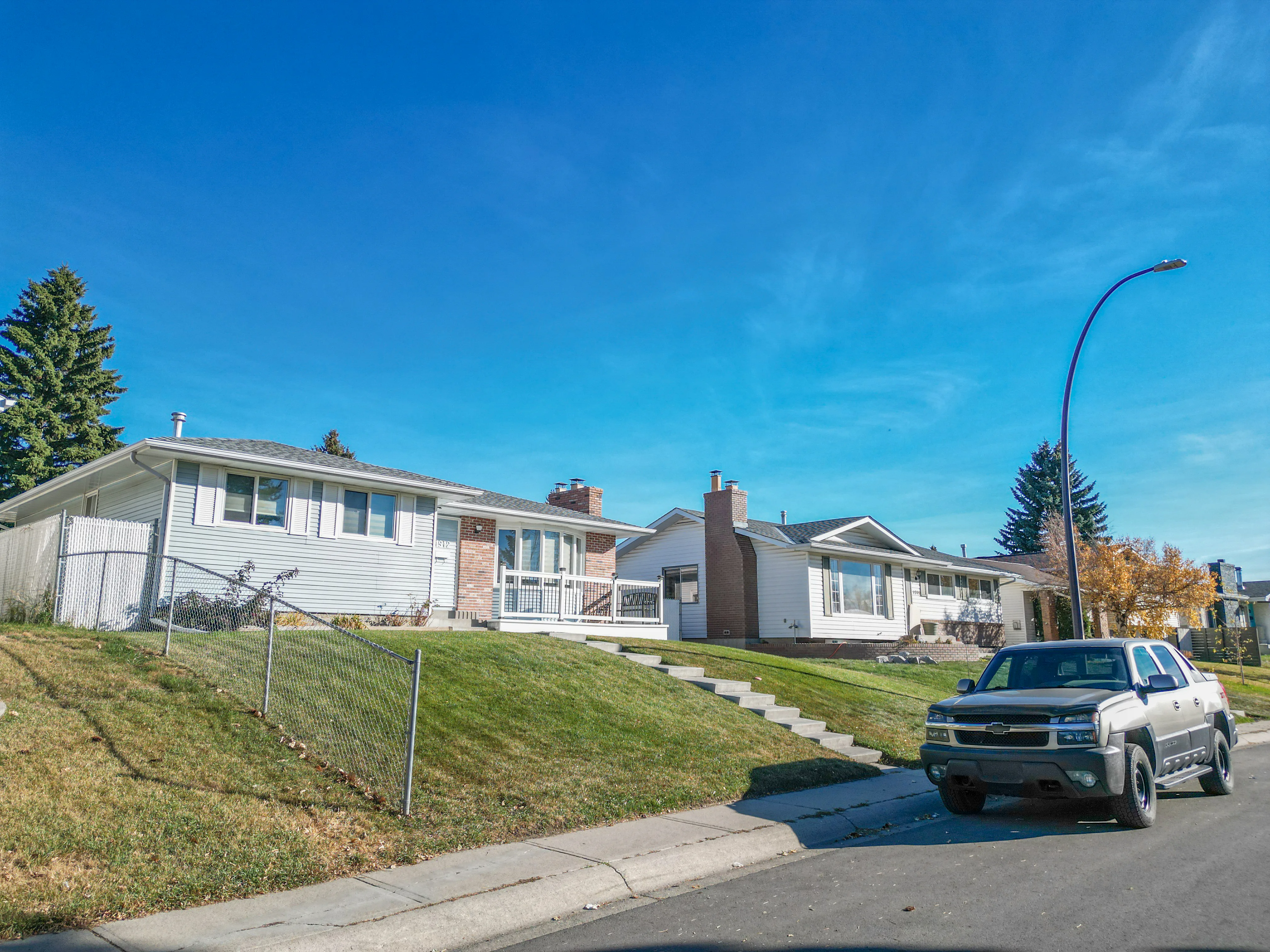 Raised bungalow with a front lawn on a residential street
