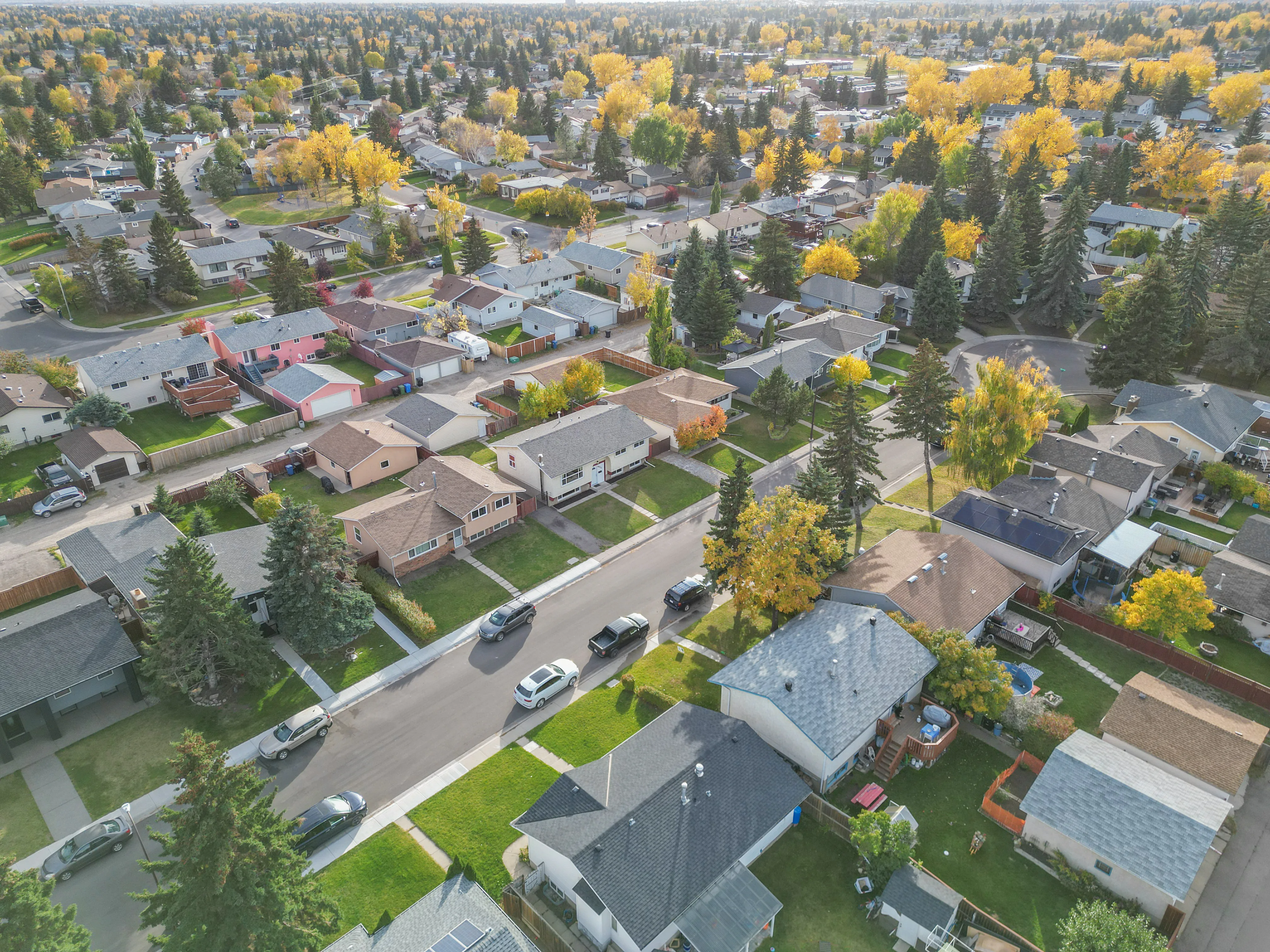Aerial of bungalows on wide lots with yellow autumn trees