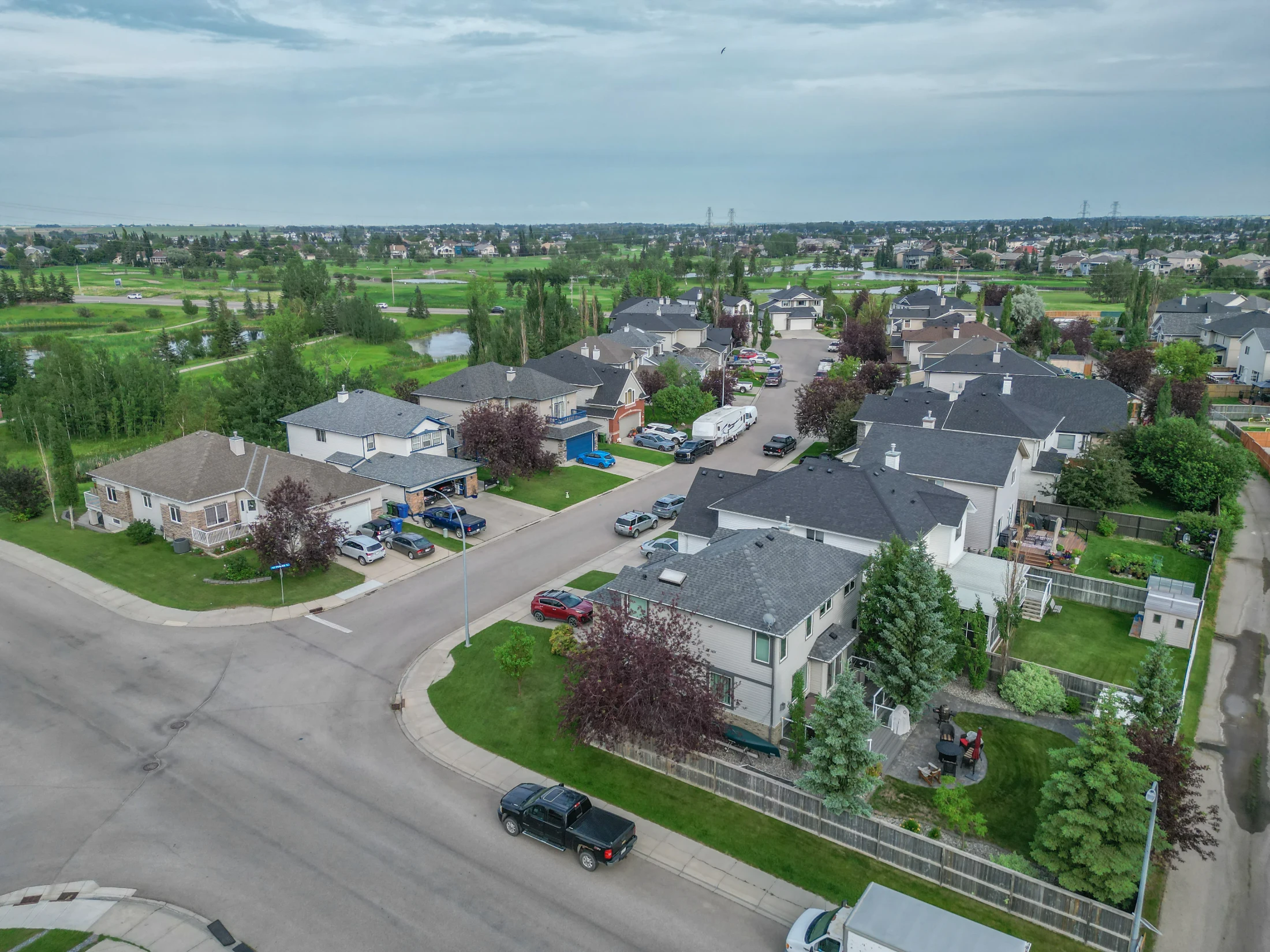Aerial of a neighbourhood of two-storey homes and green lawns