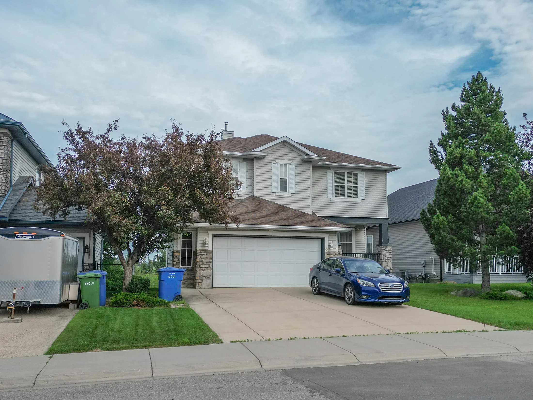 Two-storey home with a double garage and a red-leafed tree