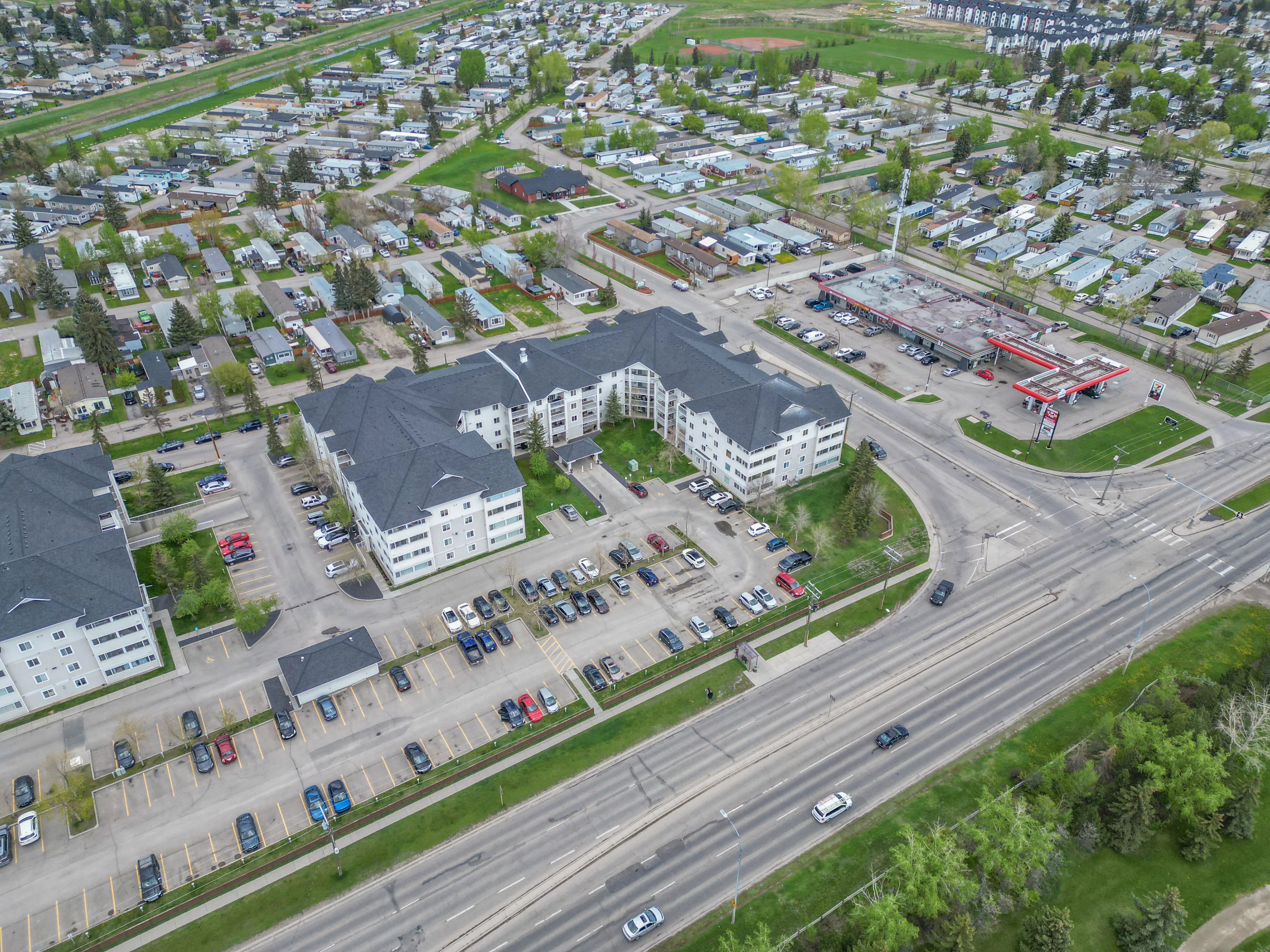 Aerial of low-rise condo buildings and surface parking