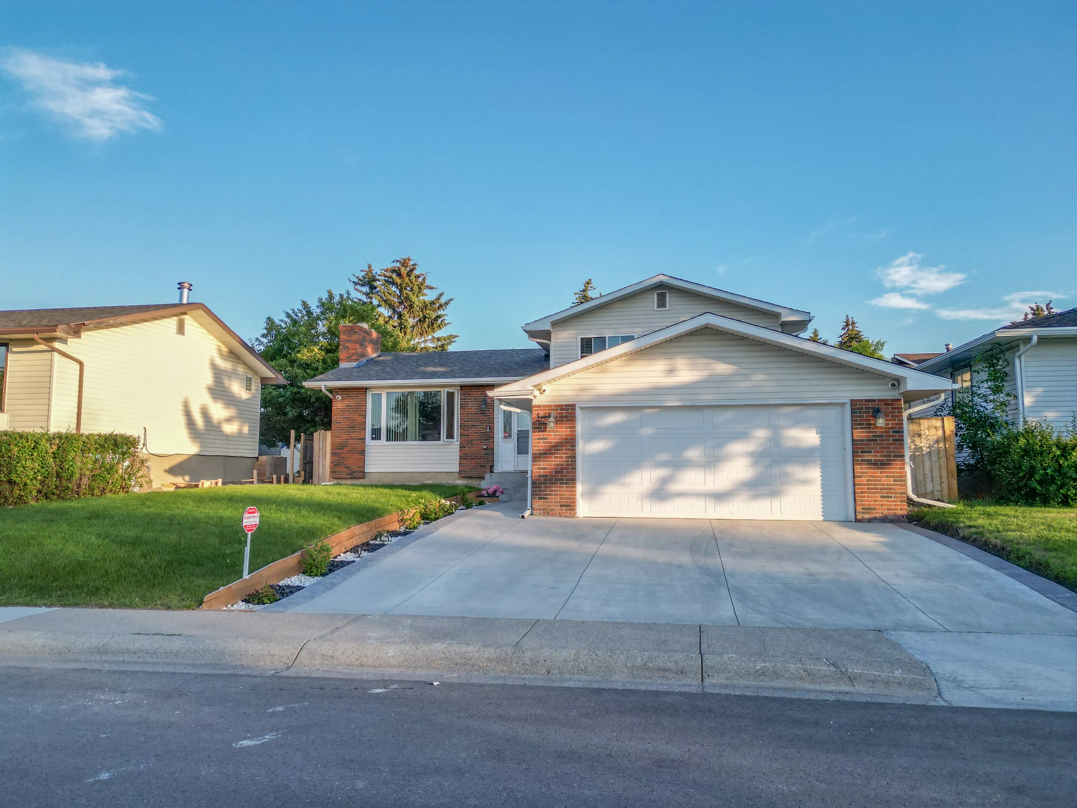 Bungalow with a white garage door and a front lawn