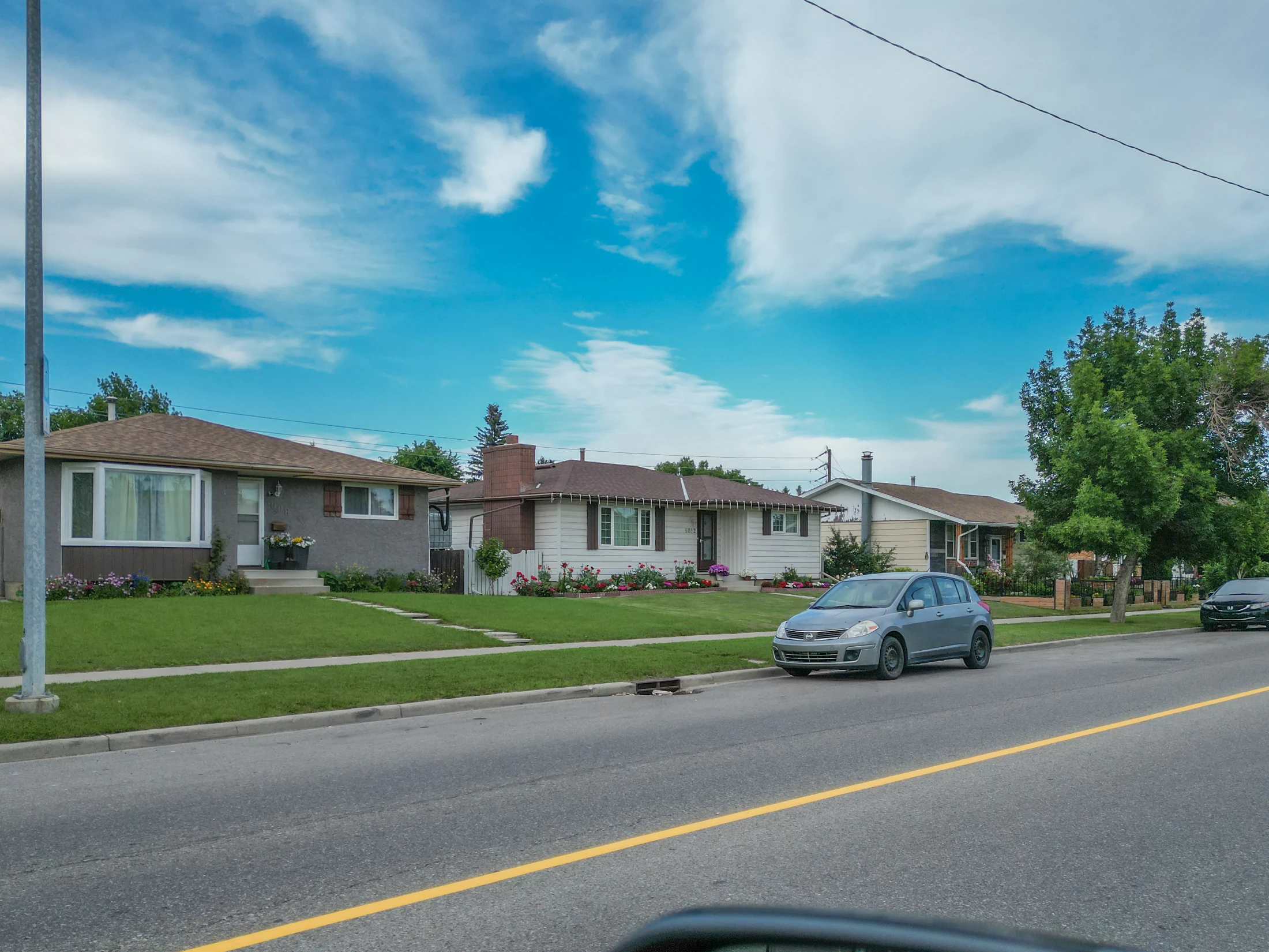 Older bungalow and front yard on a tree-lined street