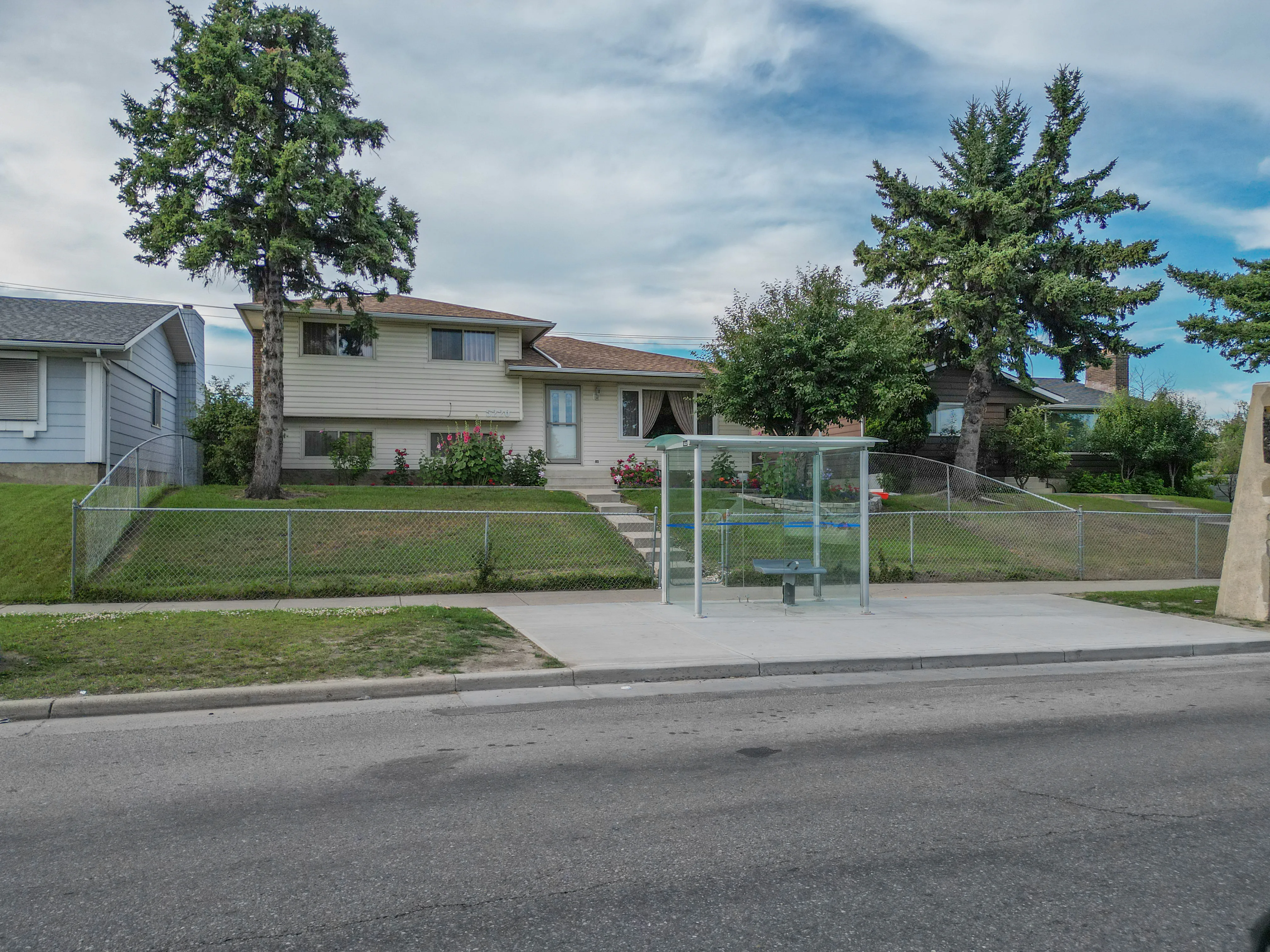 Split-level home with a front lawn and mature trees