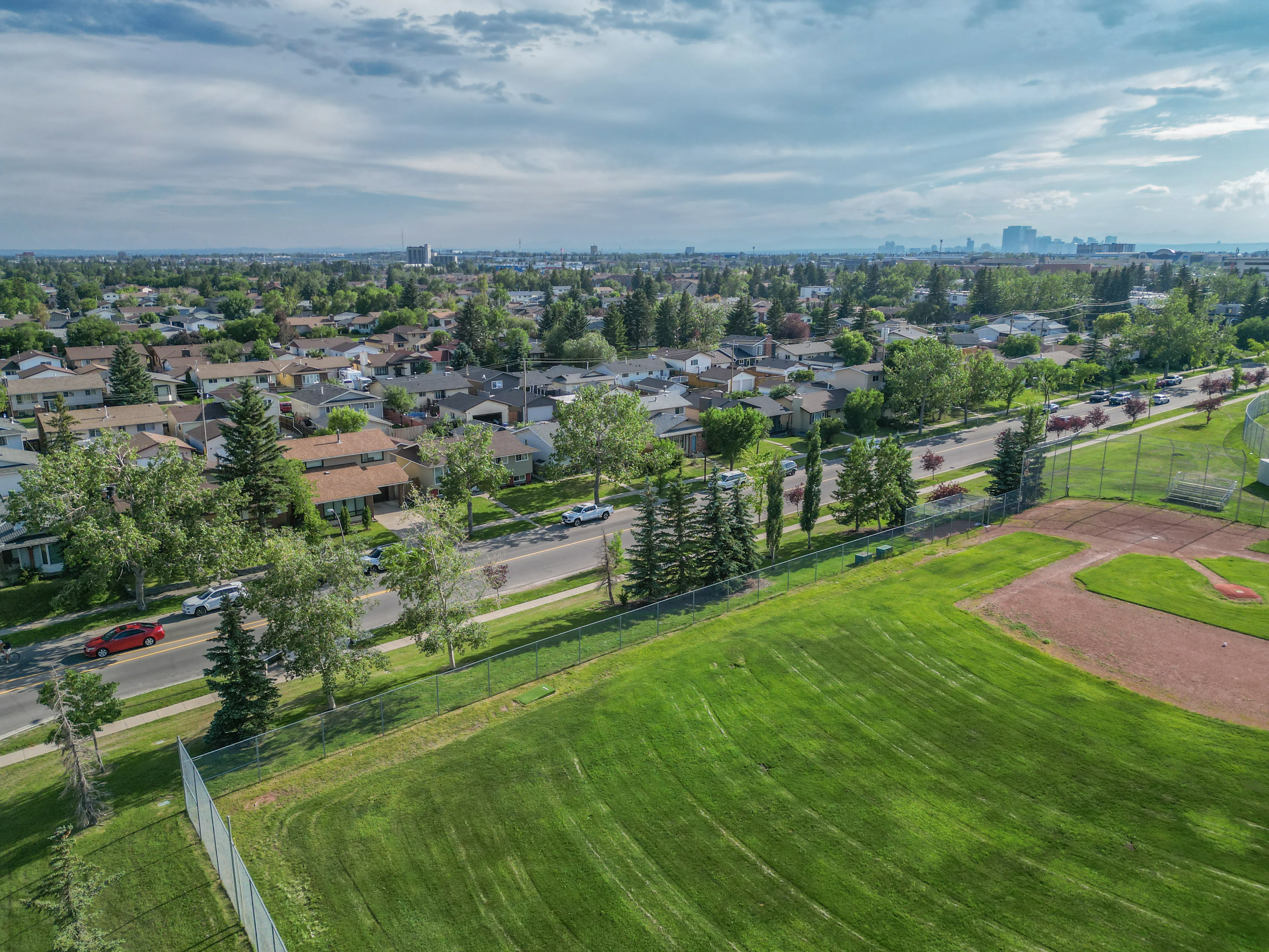 Aerial of a ball diamond and green space beside homes