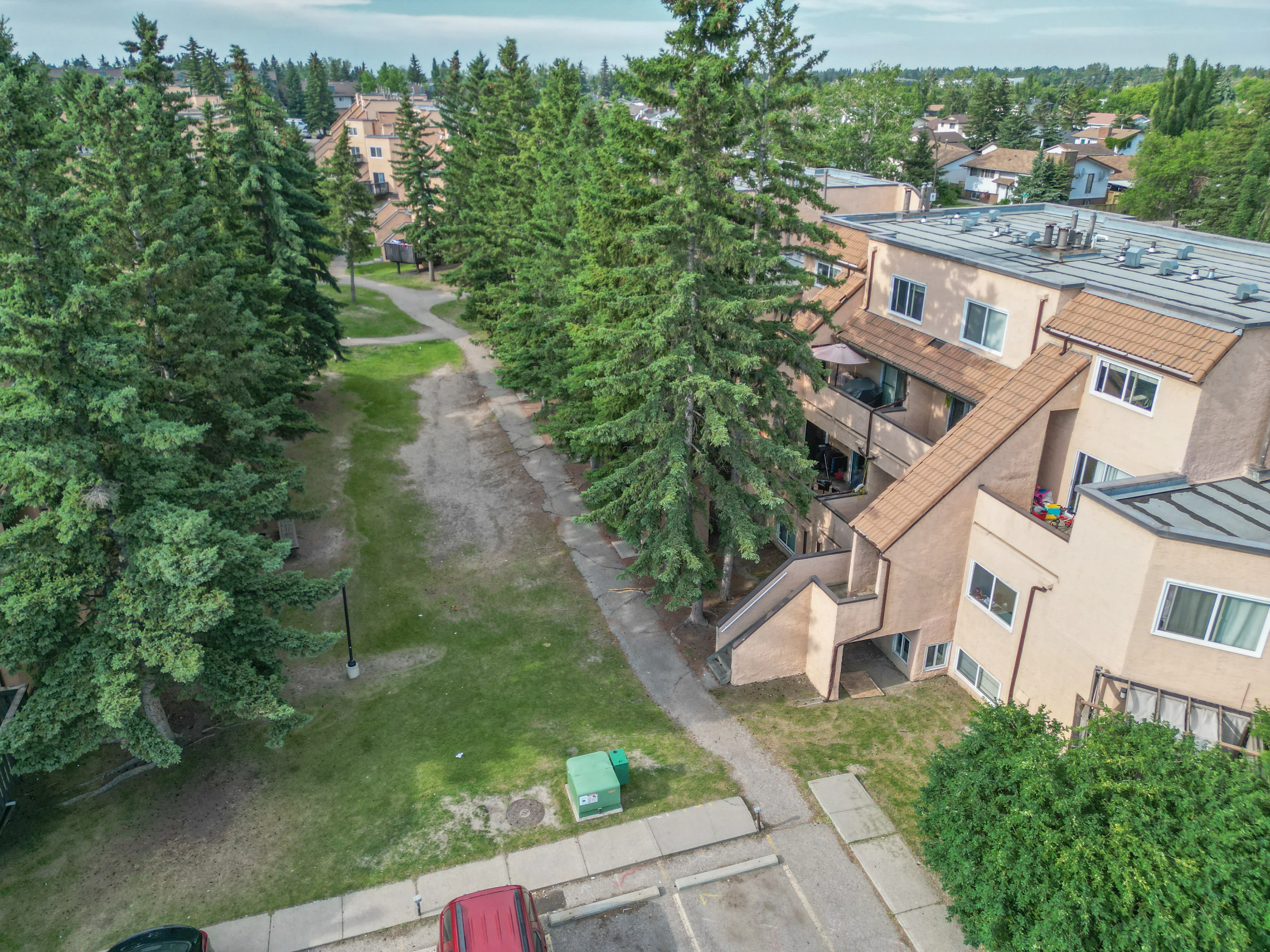 Older townhome complex beside a treed walking path