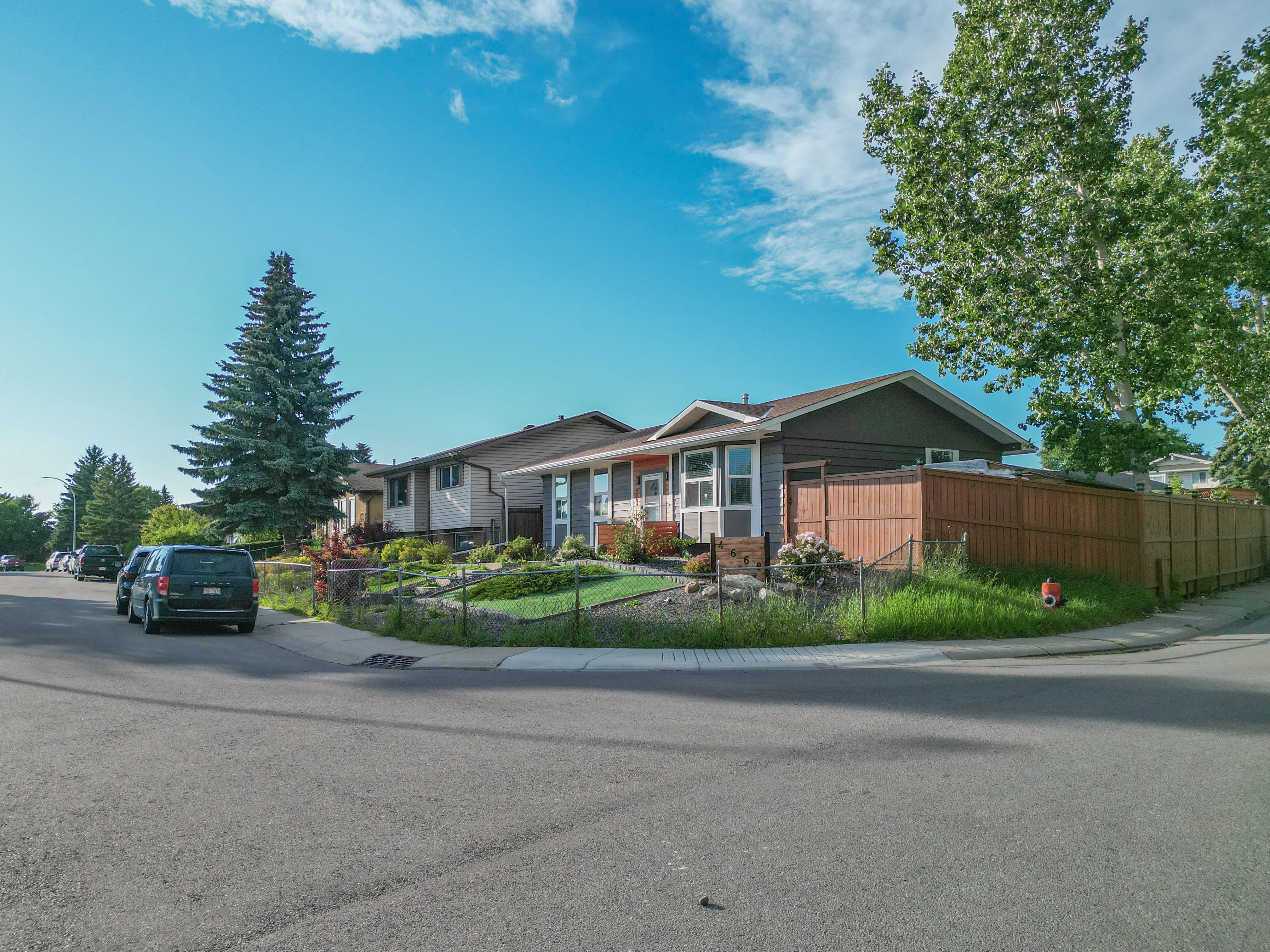 Bungalow with a front lawn and evergreen trees