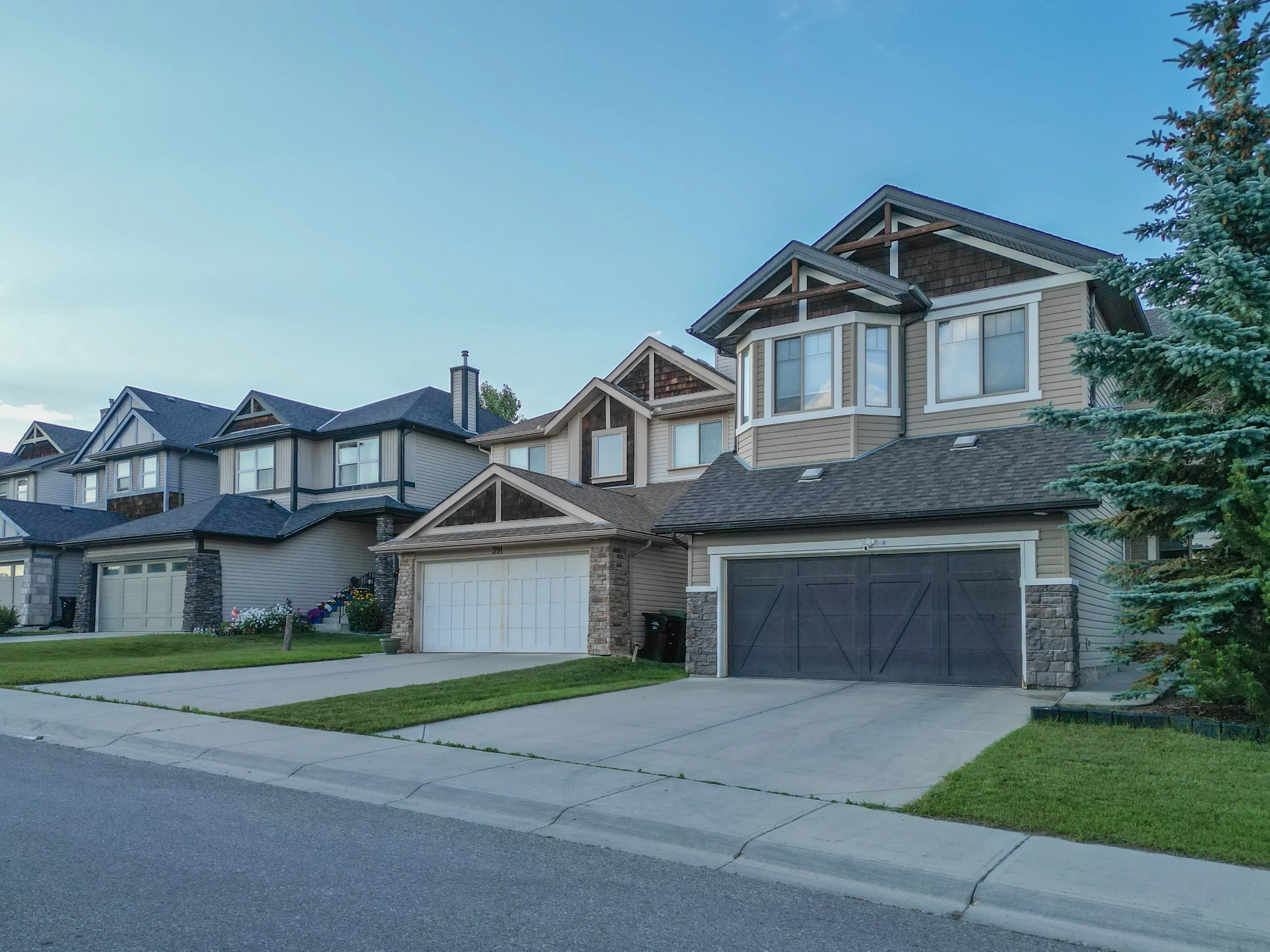 Row of two-storey homes with double garages and lawns