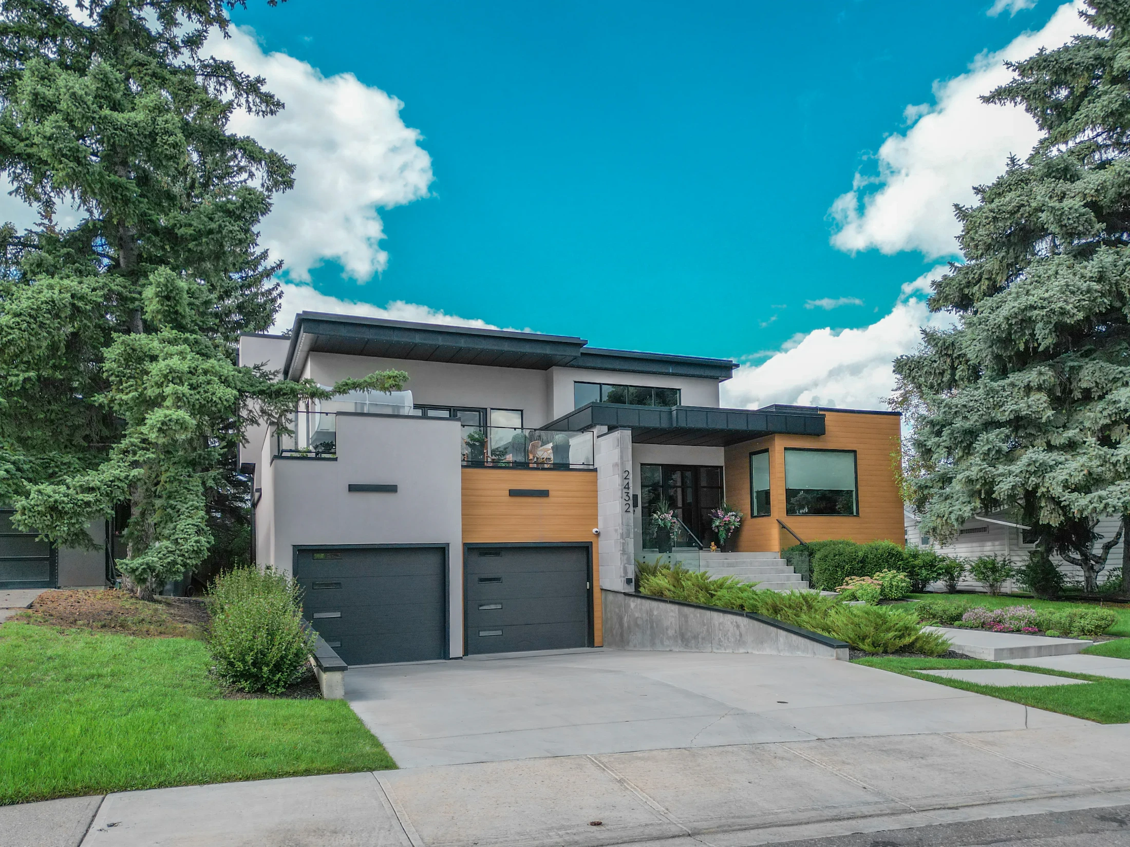 Large modern home with a double garage and mature evergreens