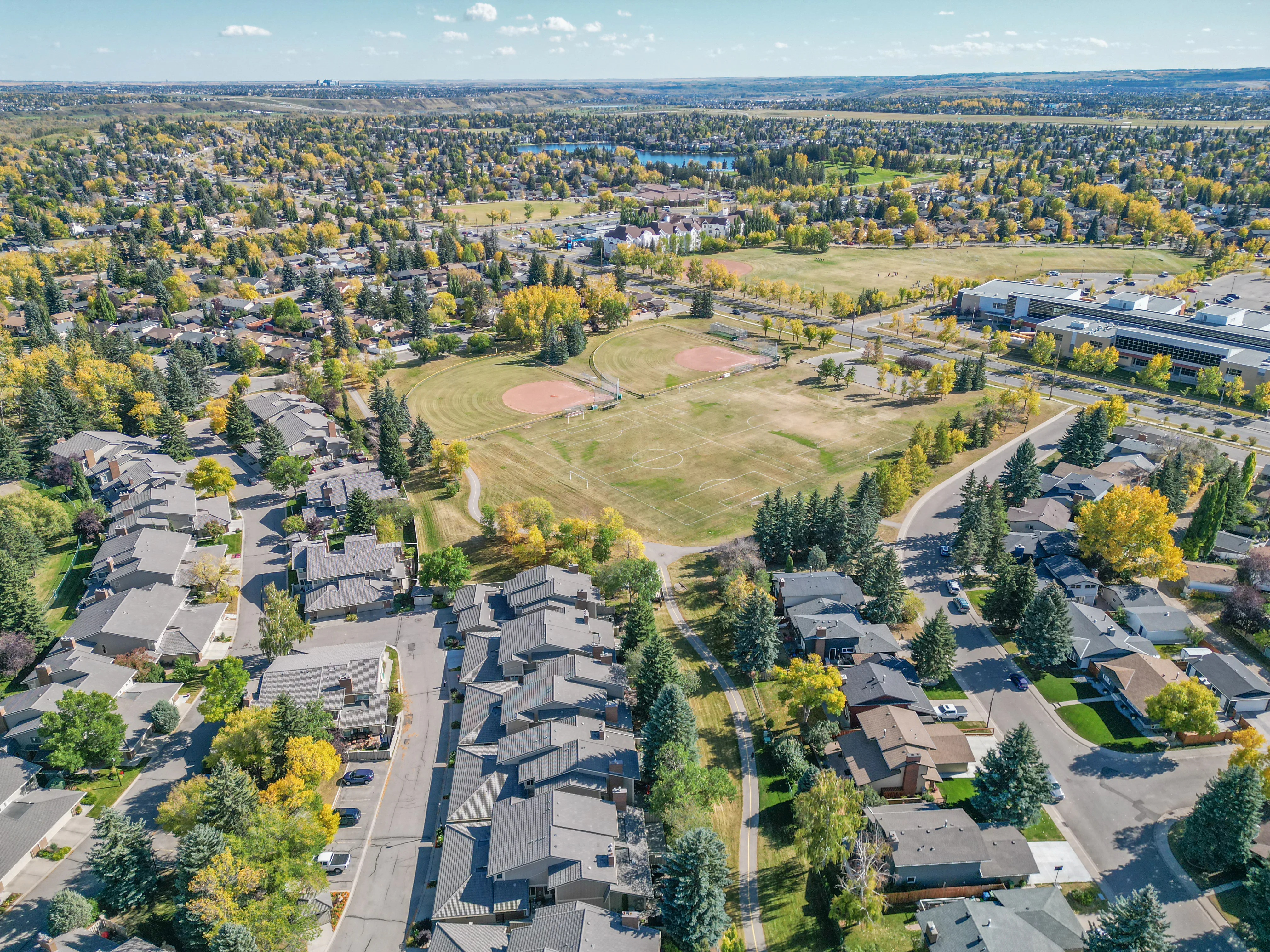 Aerial of a large sports field surrounded by homes and trees