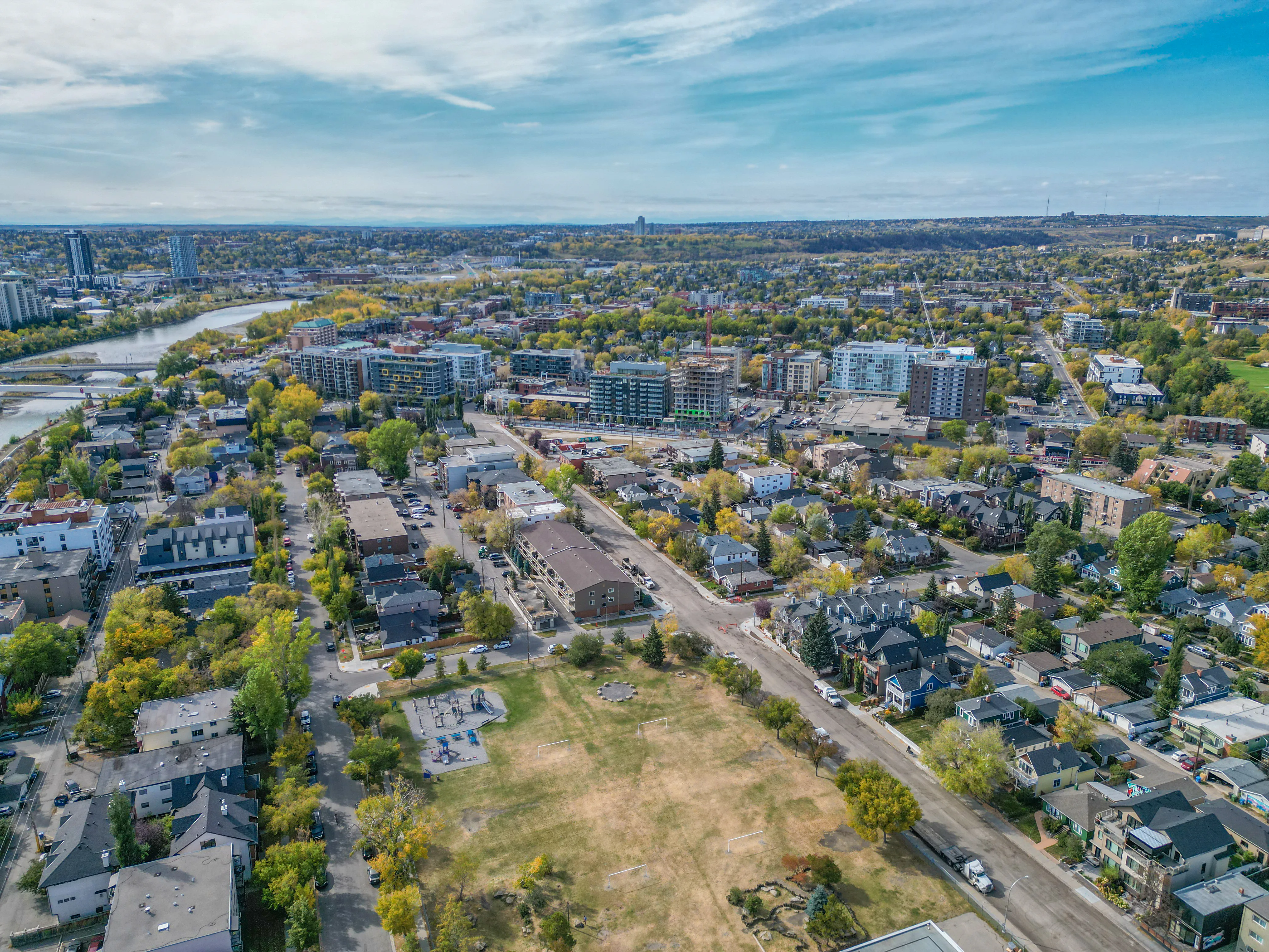 Aerial of an inner-city neighbourhood with mid-rise condos, older homes and the river