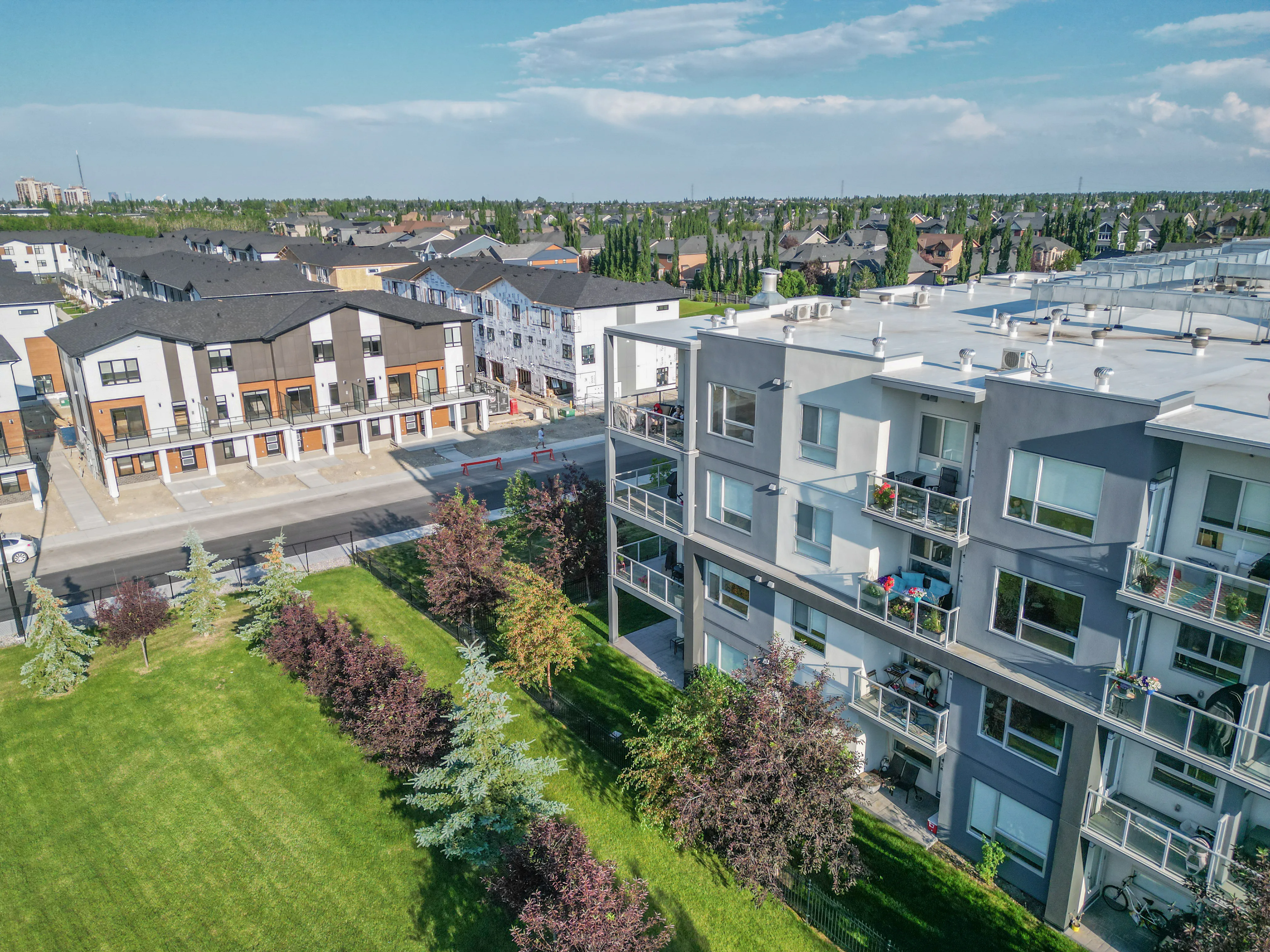 Modern townhomes beside a newer condo building and landscaping