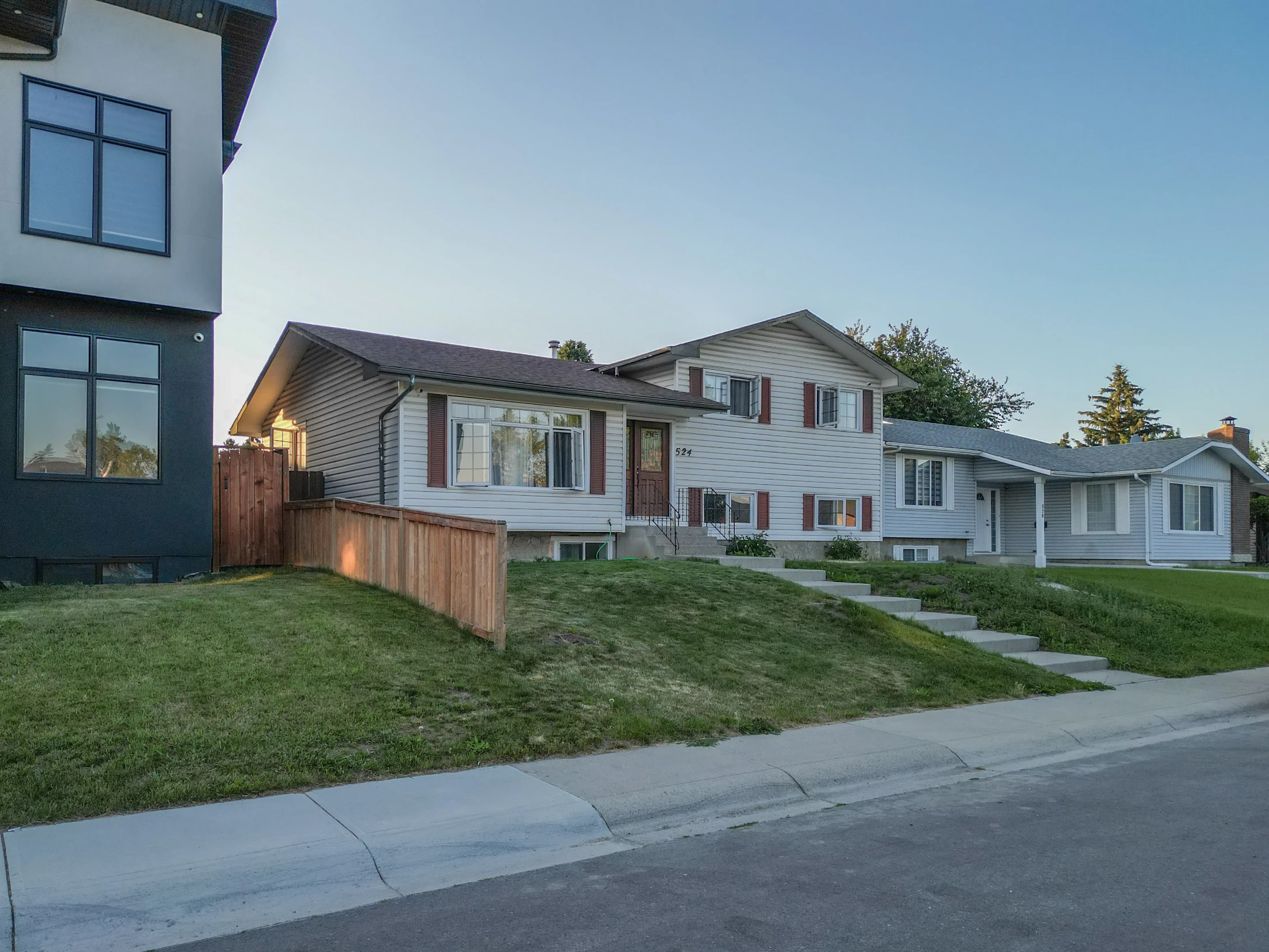 Split-level home with a sloped lawn on a residential street